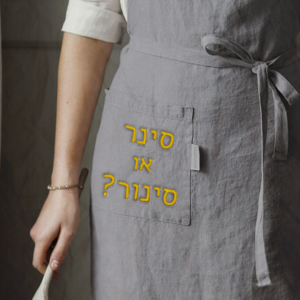 צילום של אישה עם סינור והכיתוב: סינר או סינור?